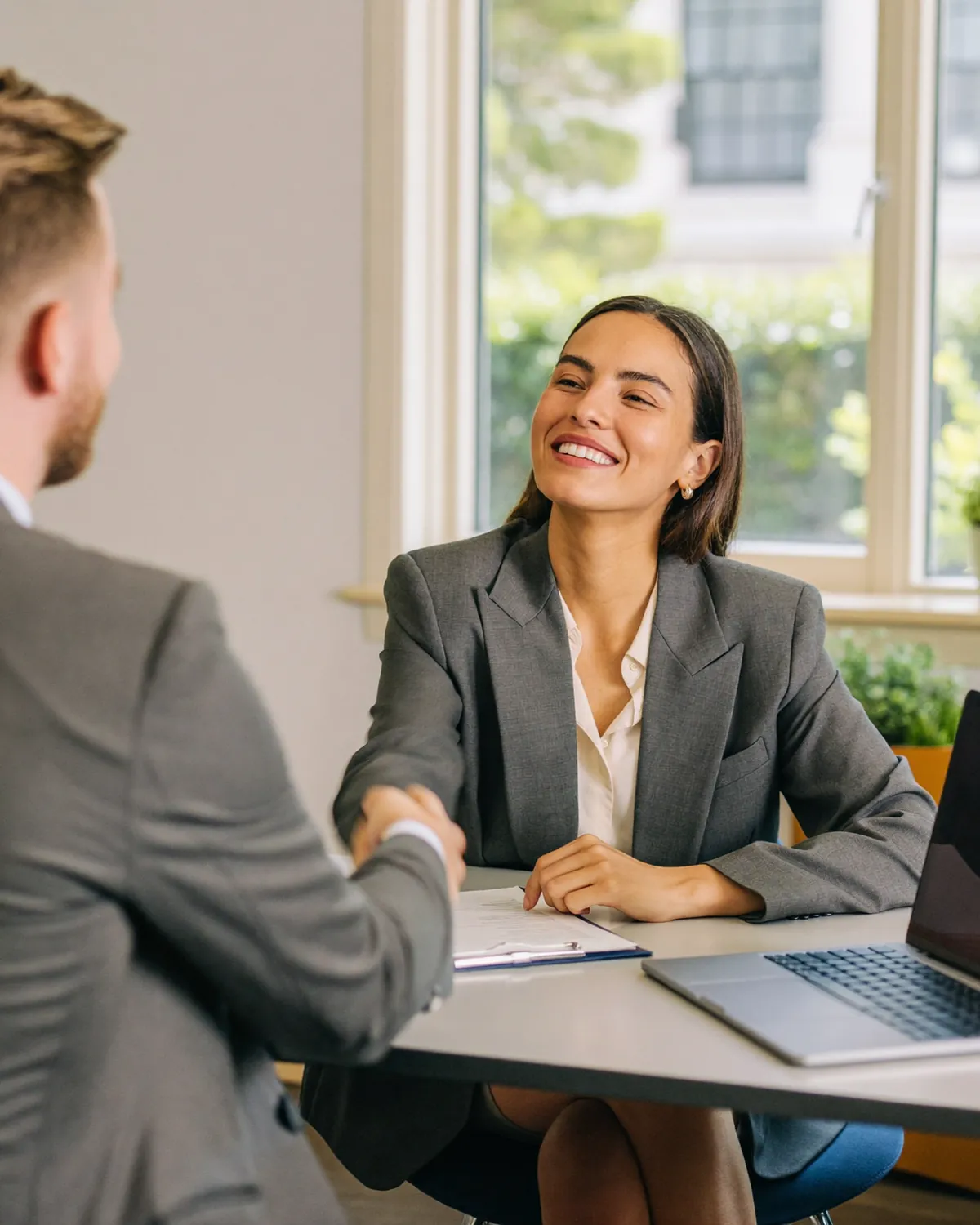 Two professionals in a one-to-one coaching conversation in a bright room