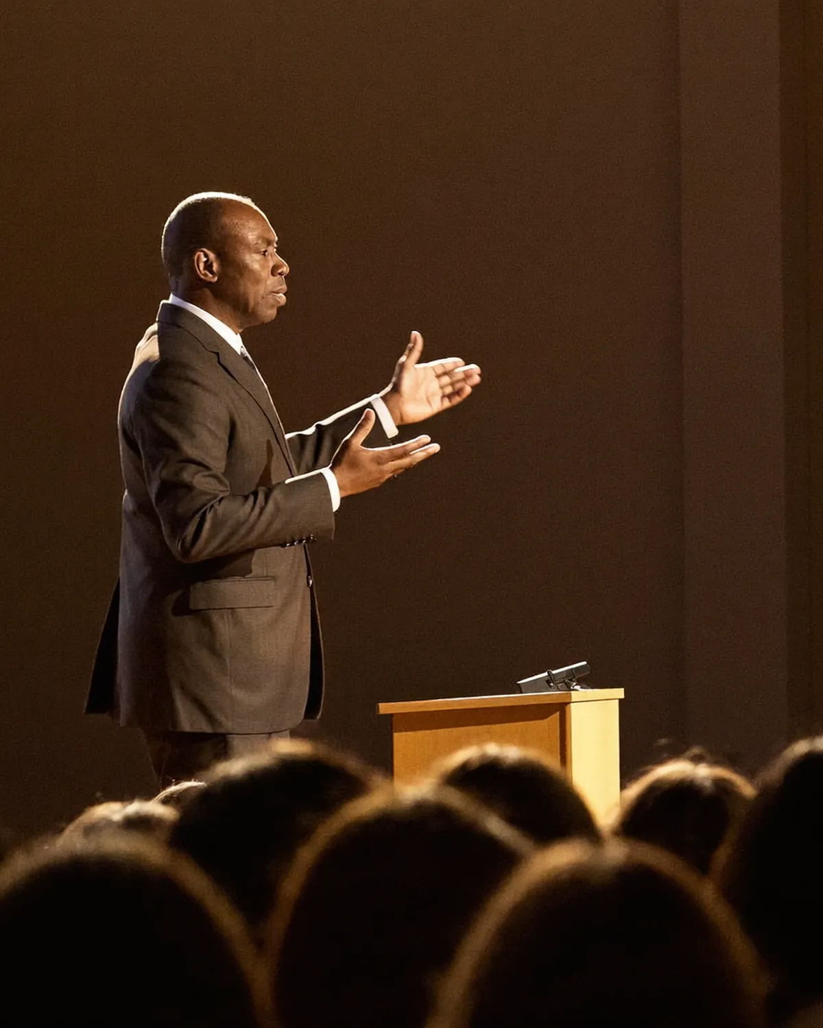 A speaker delivering a keynote on a conference stage in front of a large audience