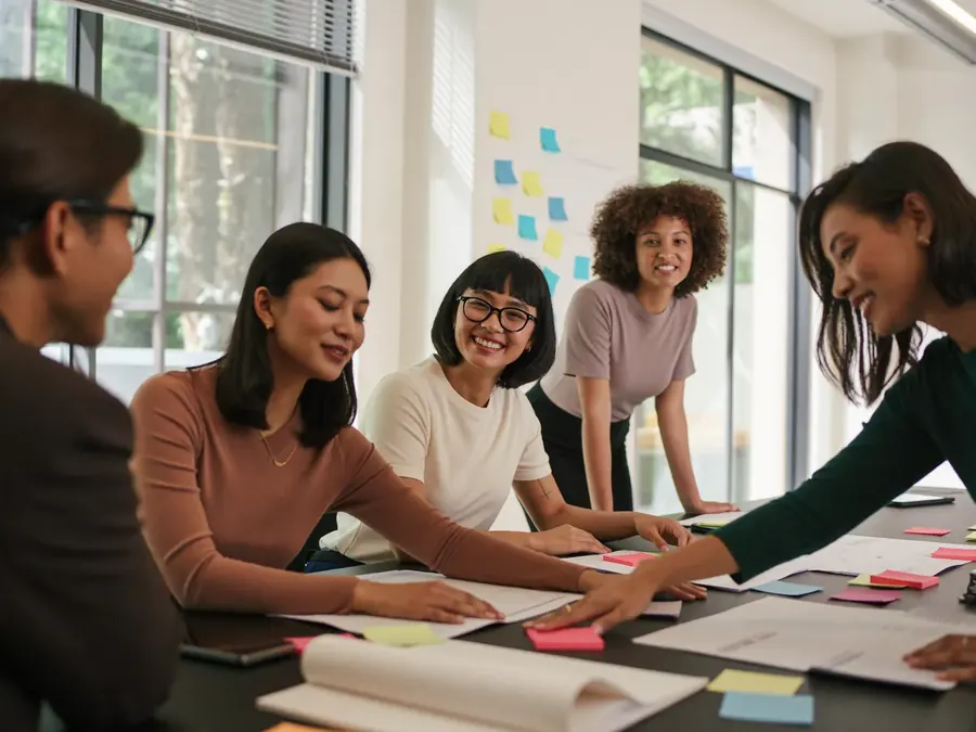 Five colleagues collaborating around a table covered in sticky notes